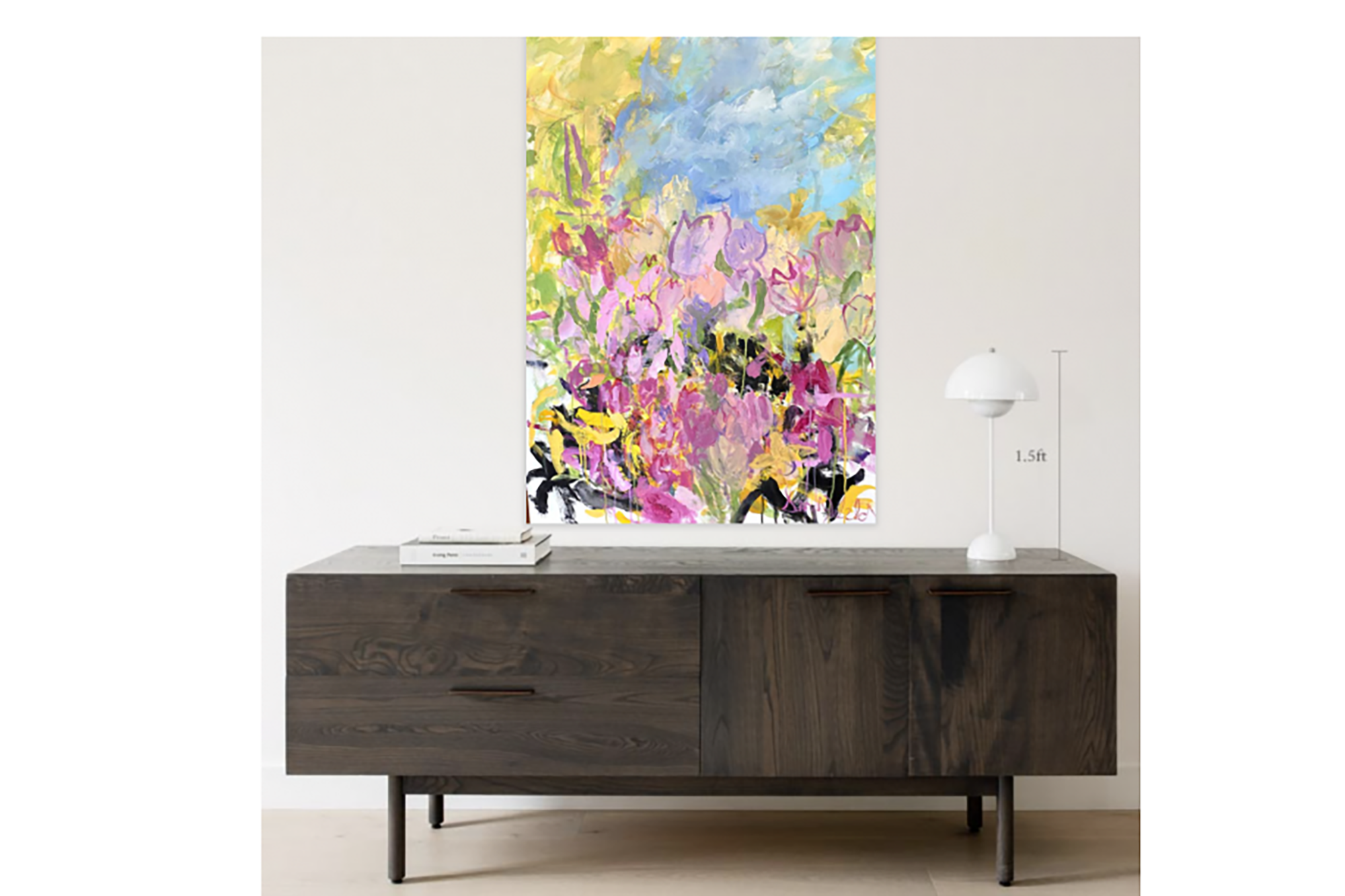 A painting of pastel flowers on a white wall above a brown table