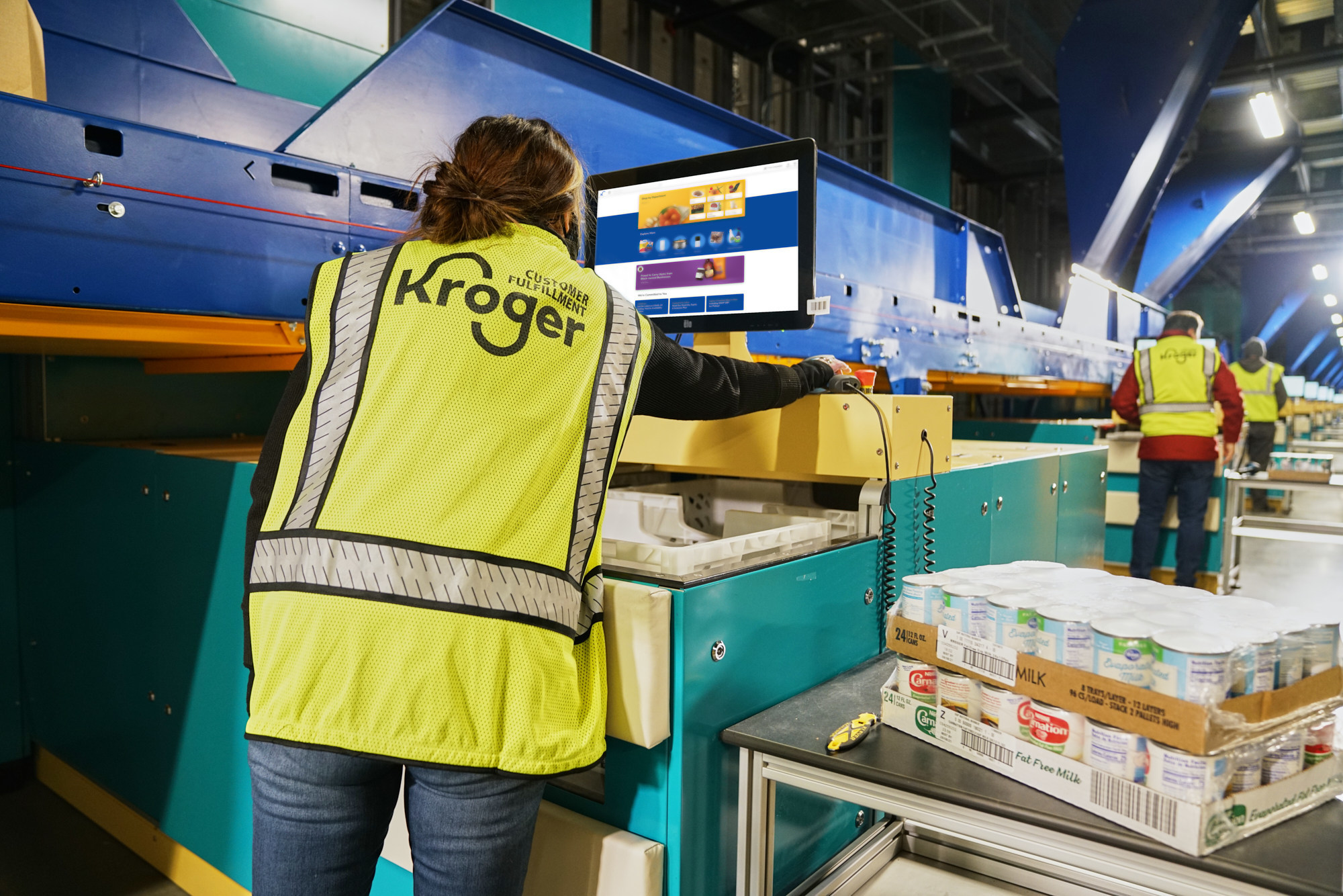 A Kroger warehouse worker, putting items in a box.