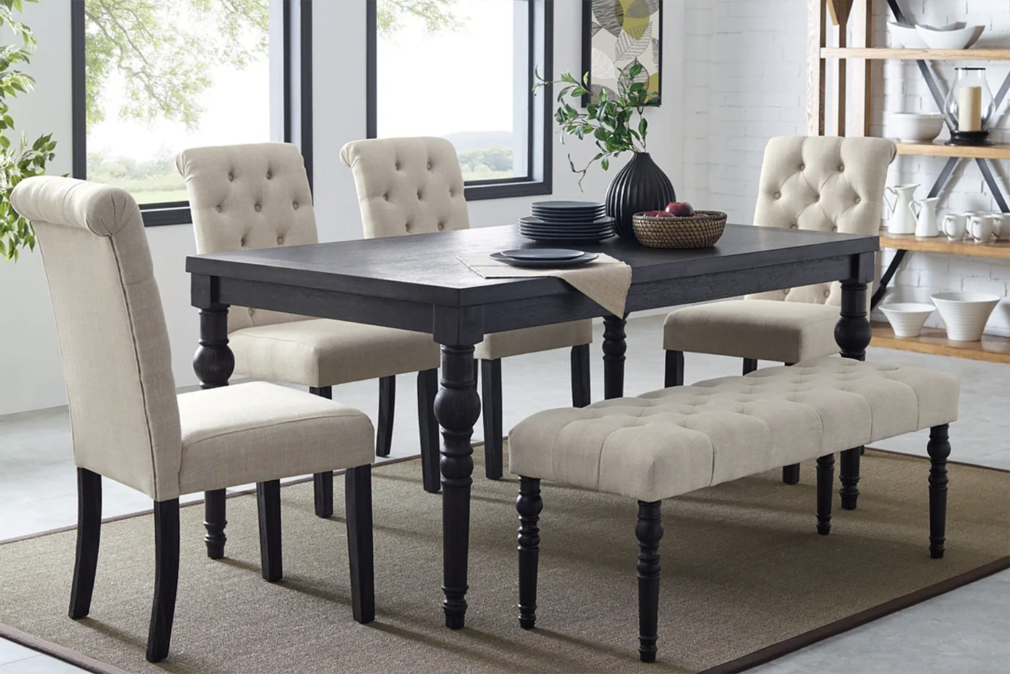 A dining room set up with off white furniture and a dark table 