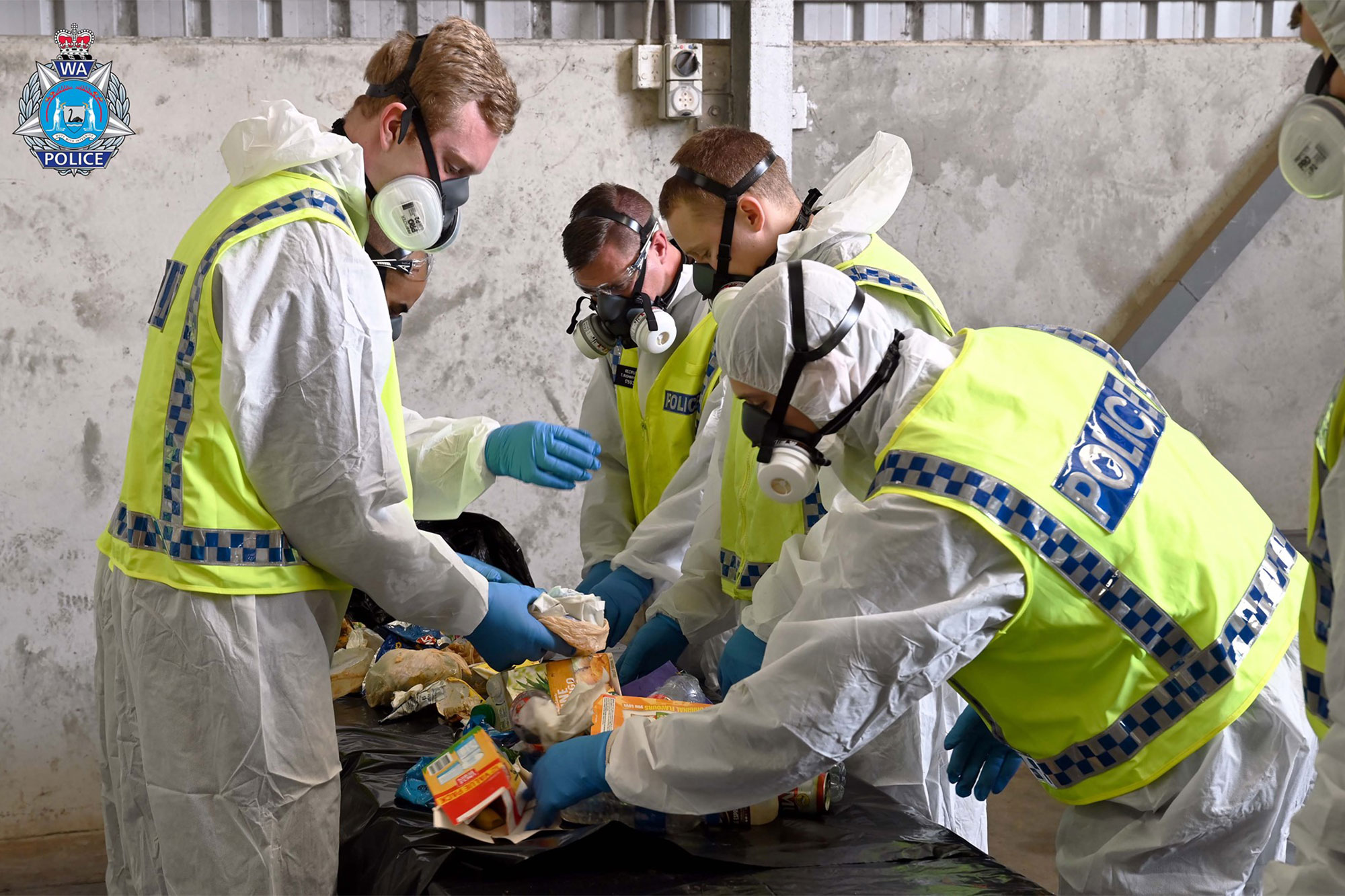 Police search through materials looking for evidence in the hunt for the now found Cleo Smith.