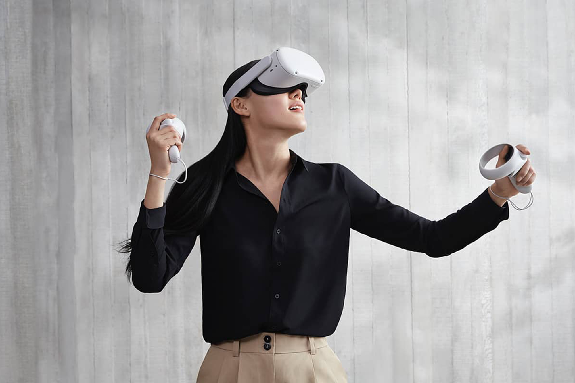 A woman with an Oculus headset in a gray room 