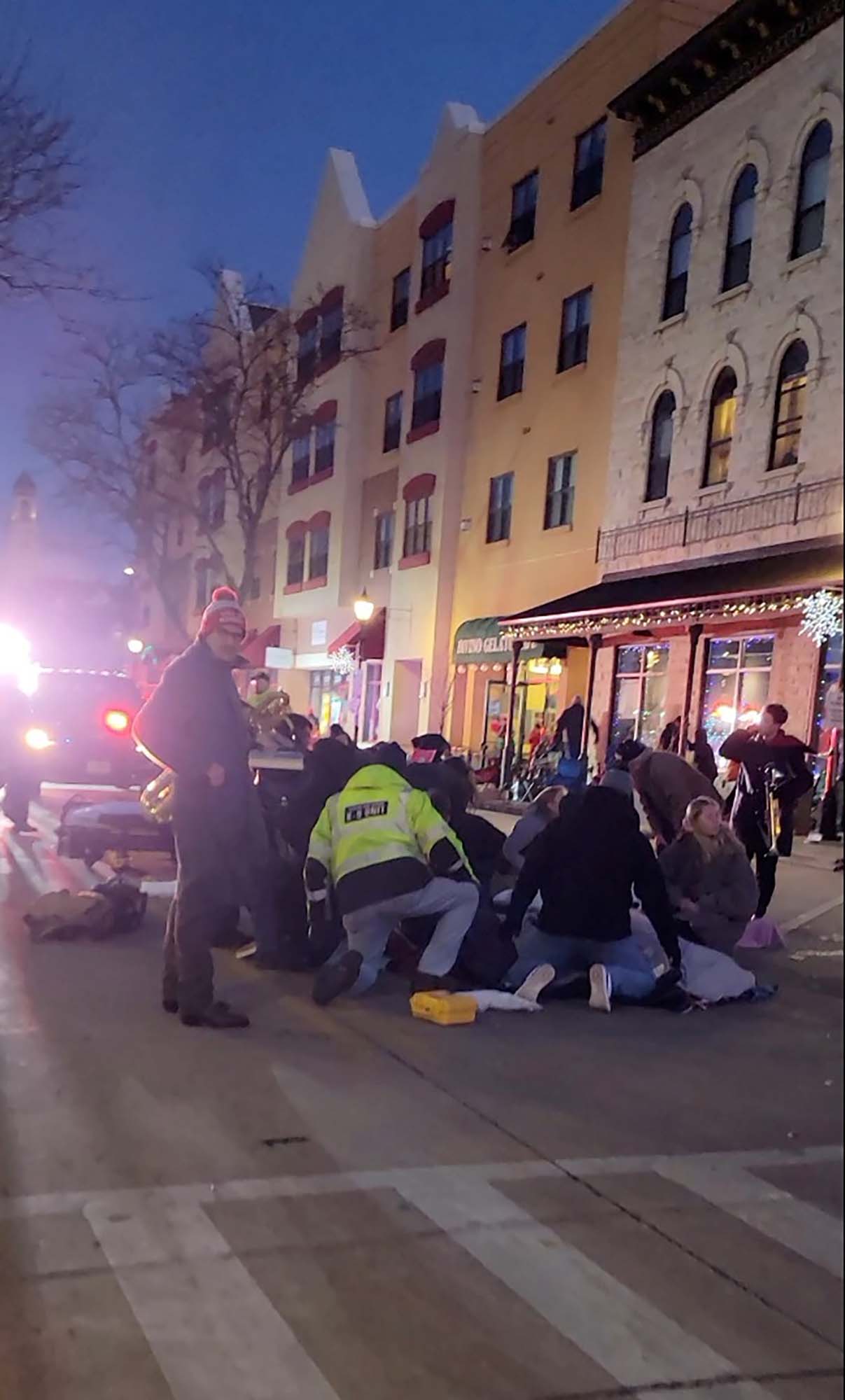Emergency responders and passersby attend to injured people after a vehicle plowed through the crowd.