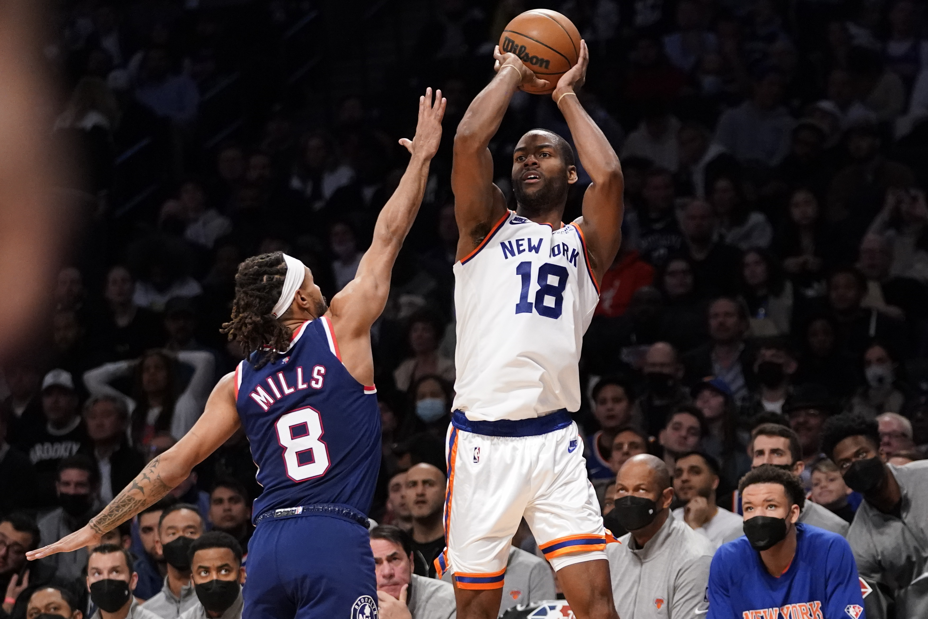 Knicks guard Alec Burks shoots a 3-point basket over Nets guard Patty Mills during the first half of a game, Tuesday, Nov. 30, 2021.