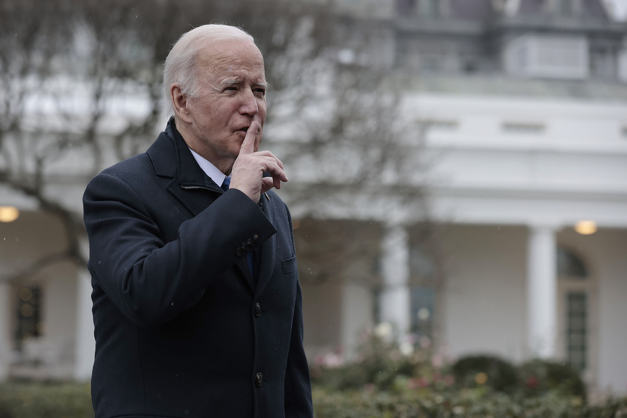 President Biden holds pointer finger to mouth