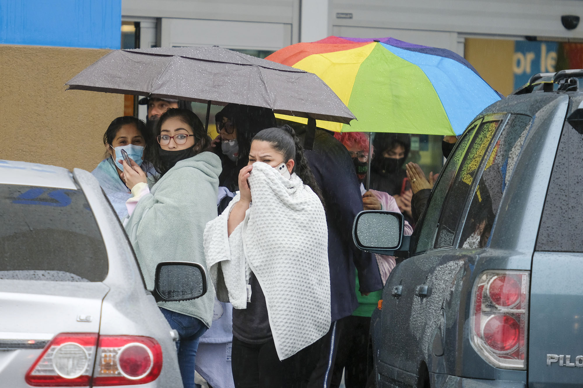 Shoppers are seen at the scene where two people were struck by gunfire in a shooting at the Burlington store